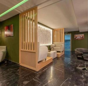 una sala de estar con paredes verdes y muebles blancos. en High standing apartment, en Marrakech