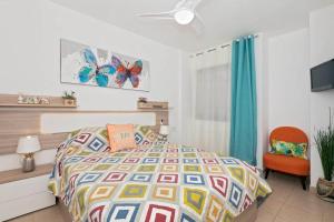 1 dormitorio con 1 cama y 1 silla en Lovely Spacious Apartment in San Isidro Tenerife en San Isidro