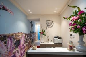 una habitación con jarrones de flores sobre una mesa en Profumi di Primavera Luxury Rooms en Matera