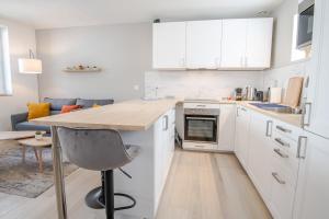 a kitchen with white cabinets and a table and a chair at Le cosy pad in Amboise