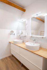 a bathroom with two sinks and a mirror at Le cosy pad in Amboise
