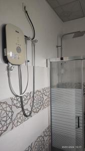 een douche in een badkamer met een glazen deur bij Laxsume Guest House Nilaveli in Nilaveli