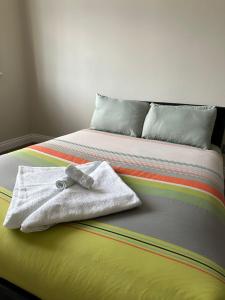 - une serviette blanche assise au-dessus du lit dans l'établissement westcliff on sea, à Southend-on-Sea