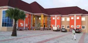 ZariaJoclarif Hotel and Suites的手掌树屋前行走的人