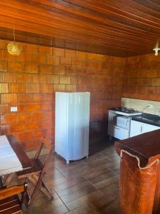 uma cozinha com um frigorífico branco e um fogão em Chalés Canto Das Águas em Bueno Brandão