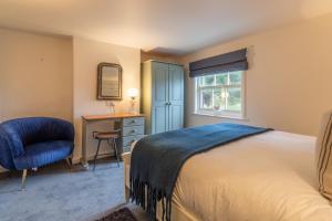 a bedroom with a bed and a desk and a chair at Bracken Cottage in Brancaster