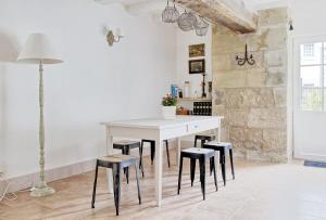 kuchnia z białym stołem i stołkami w obiekcie Domaine La Restrie - L'Atelier de Raphaël w mieście Pocé-sur-Cisse