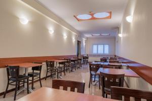 una sala da pranzo con tavoli e sedie in legno di Hotel Monte Verde a Roma