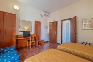 um quarto com uma cama e uma secretária com uma televisão em Hotel Monte Verde em Roma