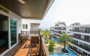 een balkon met uitzicht op een zwembad bij The Beach Palace in Ban Bo Khaem