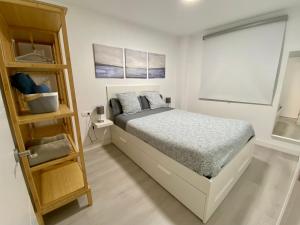 een witte slaapkamer met een bed en een raam bij Las Arenas de la Carihuela in Torremolinos