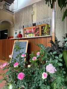 una muestra de flores en un edificio con un cartel en DE ROSE Hotel Chiang Mai, en Chiang Mai