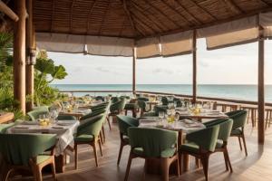 a restaurant with tables and chairs with the ocean in the background at Ocean Boutique Hotel in Pingwe