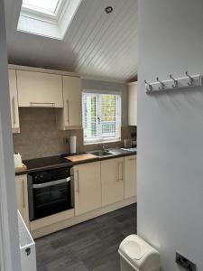 a kitchen with white cabinets and a skylight at V+B Hygge in Windermere