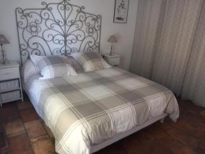a bedroom with a bed with a black and white comforter at Mas Sicard chambre d'hôtes en Camargue in Arles