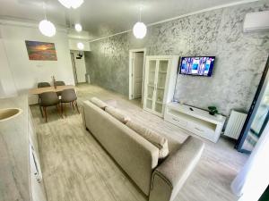 uma sala de estar com um sofá e uma televisão de ecrã plano em Aqua Apartament Mamaia em Mamaia