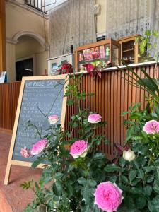 un cartel con rosas rosas frente a un restaurante en DE ROSE Hotel Chiang Mai en Chiang Mai