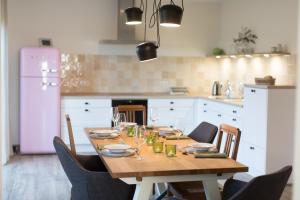 a kitchen with a wooden table with chairs and a kitchen with white cabinets at Ferienhaus "Sonne im Grünen" in Lindern