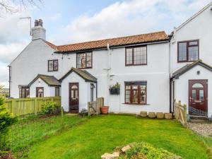 an exterior view of a white house with a yard at 4 Bed in Langtoft 81235 in Weaverthorpe