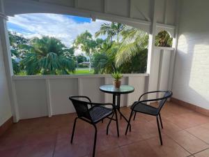 a balcony with a table and two chairs and a window at Sans Souci Apartments in Ingham