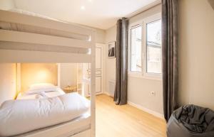 een slaapkamer met een stapelbed en een raam bij Maison hyper centre avec cour arborée - 6pers. in Amboise