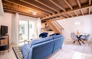 een woonkamer met een blauwe bank en een tafel bij Maison hyper centre avec cour arborée - 6pers. in Amboise