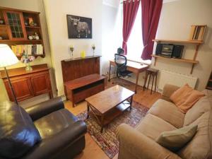 a living room with a couch and a table at Pass the Keys Spacious and Comfortable 3 Bed Home in Birkenhead in Birkenhead