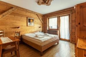 um quarto com uma cama num quarto de madeira em Nord Hotel em Cortina dʼAmpezzo