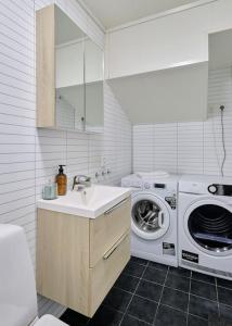 baño blanco con lavadora y lavamanos en Sentrumsnær og Romslig 4-roms Leilighet en Bergen