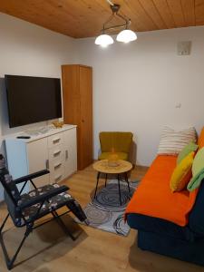 a living room with a couch and a tv and a table at Kociol Duzy 24 in Kocioł