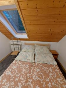 a bed in a small room with a window at U Andrzeja i Ewy in Kocioł