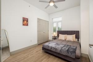 een slaapkamer met een bed en een plafondventilator bij CityScape Flat- 3BR Luxury APT in Uptown in Charlotte