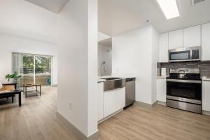 シャーロットにあるCityScape Flat- 3BR Luxury APT in Uptownのキッチン(白いキャビネット、コンロ付)