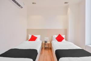 2 camas en una habitación con almohadas rojas en THE PARADISE INTERNATIONAL en Coimbatore