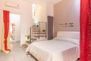 ein Schlafzimmer mit einem weißen Bett und einem roten Vorhang in der Unterkunft Casa Cellini - Piombino Apartments in Piombino