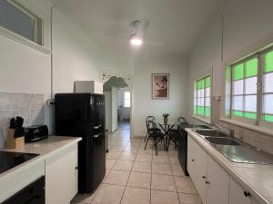 a kitchen with a black refrigerator and a table at Sans Souci Apartments in Ingham