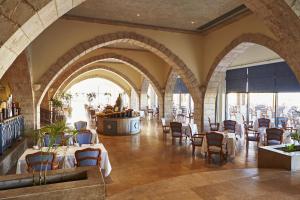 a restaurant with tables and chairs in a room at Kempinski Hotel Soma Bay in Hurghada