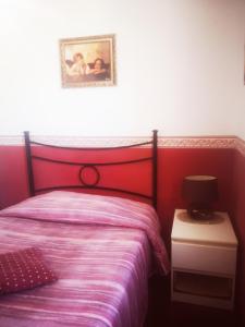 um quarto com uma cama com uma cabeceira vermelha em B&B Camera per uomini em Pescara