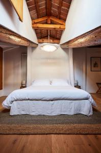 維琴察的住宿－L’Abbaino，一间卧室设有一张带木制天花板的大床。