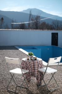 2 Stühle und ein Tisch mit einer Tischdecke drauf. in der Unterkunft Villa Green in Mostar