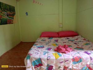 a bed with a pink comforter in a room at Ameen Homestay อามีน โฮมสเตย์ in Ban Komo Sam Sip Paet