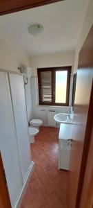 a bathroom with two toilets and two sinks at Feudo 62 in Reggio di Calabria