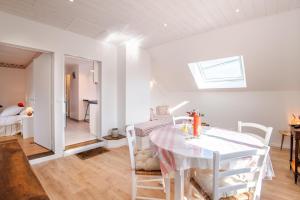 ein weißes Esszimmer mit Tisch und Stühlen in der Unterkunft Le Relais de l'Ormeau - Charmant gîte pour 4 pers. in Lussault-sur-Loire