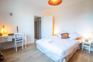 1 dormitorio con cama, escritorio y silla en Le Relais de l'Ormeau - Charmant gîte pour 4 pers., en Lussault-sur-Loire