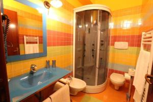 een badkamer met een wastafel, een douche en een toilet bij La Foresteria di San Leo in Trivigno