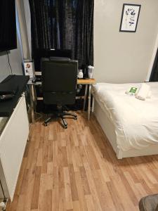 een slaapkamer met een bed en een bureau met een computer bij Umbrella Properties London Excel in Londen