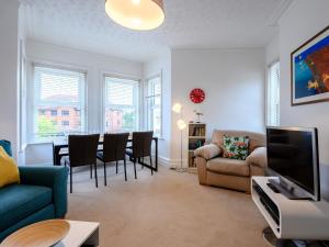 ein Wohnzimmer mit einem Sofa und einem Esszimmer in der Unterkunft 4 Bed in Bournemouth 78807 in Bournemouth