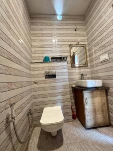 uma casa de banho com um WC e um lavatório em Laxman Jhula Retreat em Rishikesh
