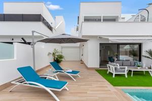 サン・ペドロ・デル・ピナタルにあるPremium Villa Mia heated poolの家の隣にパティオ(椅子、パラソル付)
