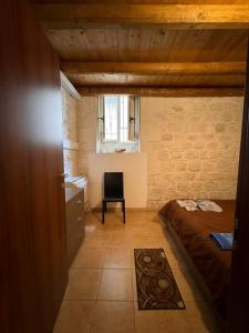 a bedroom with a bed and a window and a chair at L'insula in Scicli